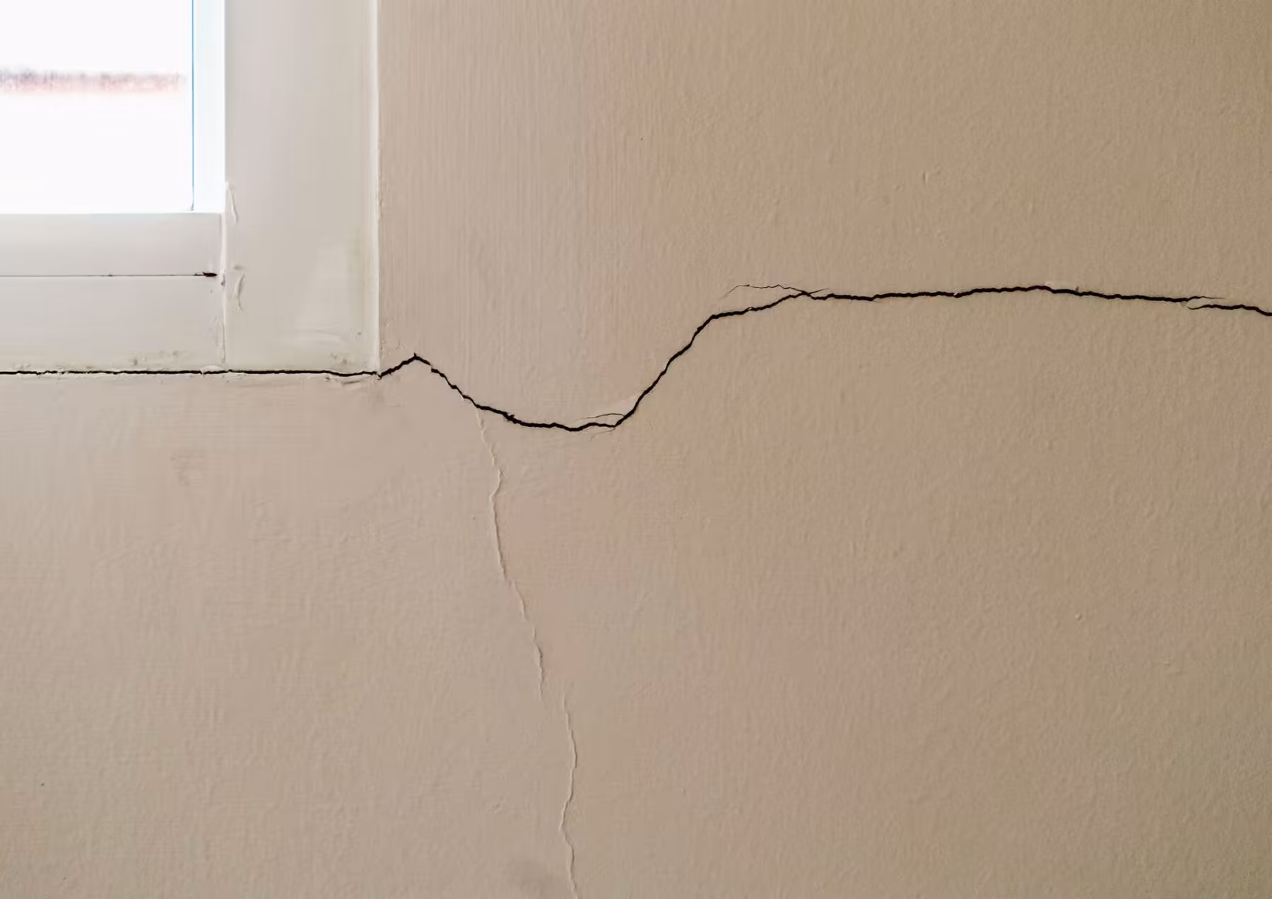 cracks in drywall around a window frame, signaling problems with the home foundation.