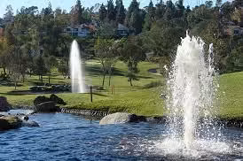 Rancho Bernardo park with water fountains, pond, trees, and residential homes in North County San Diego.